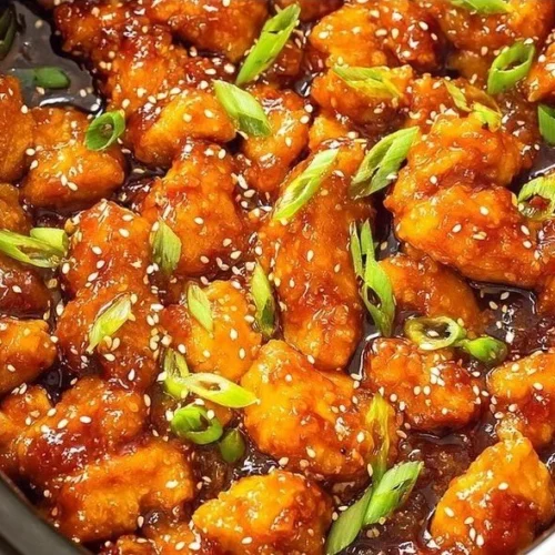 Asian Crockpot Orange Chicken dish served in a bowl with vibrant orange sauce.