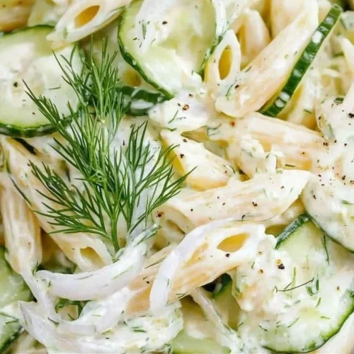 Delicious bowl of cucumber pasta salad with fresh vegetables and dressing