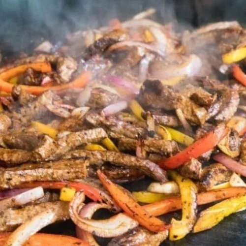 Delicious Blackstone steak fajitas served on a sizzling platter