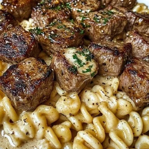 Creamy garlic butter steak bites with spicy Cajun Alfredo twisted pasta dish