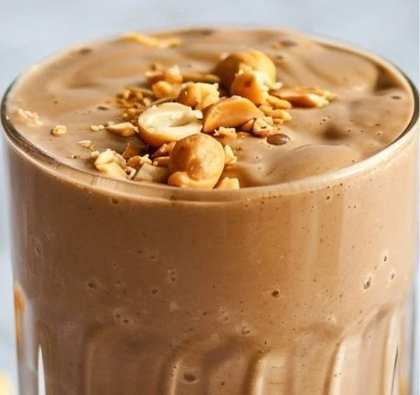 Creamy Peanut Butter Protein Smoothie in a glass with a straw