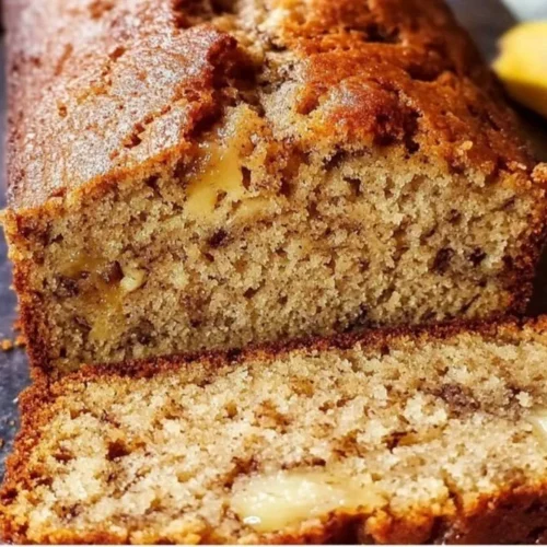 Deliciously baked banana bread topped with sliced bananas and walnuts
