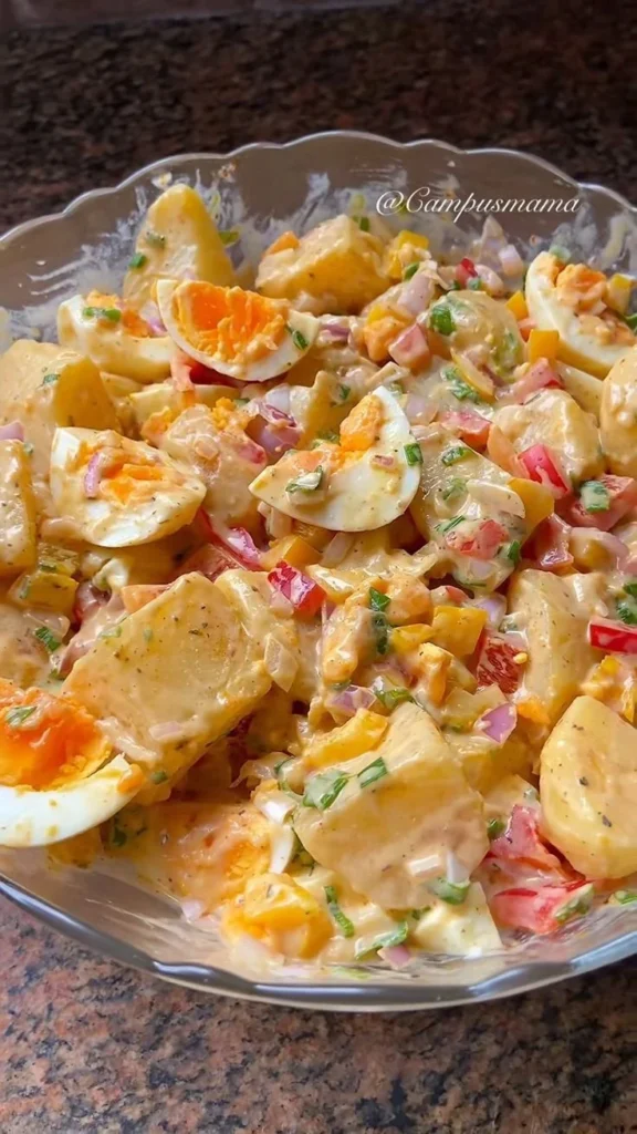 Creamy potato salad with fresh herbs and spices in a bowl