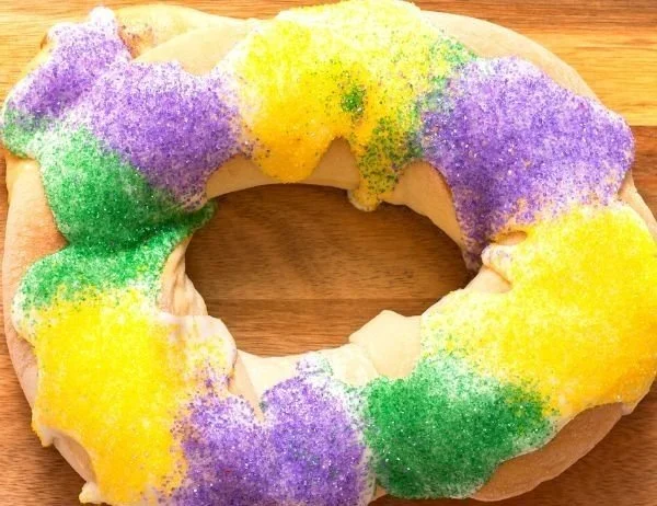 Easy King Cake decorated with colorful icing for Mardi Gras celebration