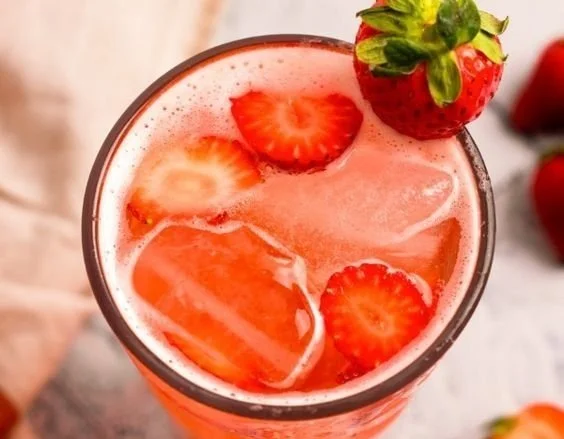 Fresh and fizzy summer drink in a glass with ice and fruit garnish