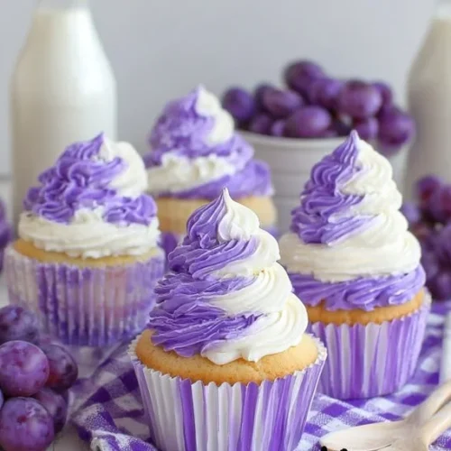 Grape soda cupcakes topped with purple frosting and colorful sprinkles