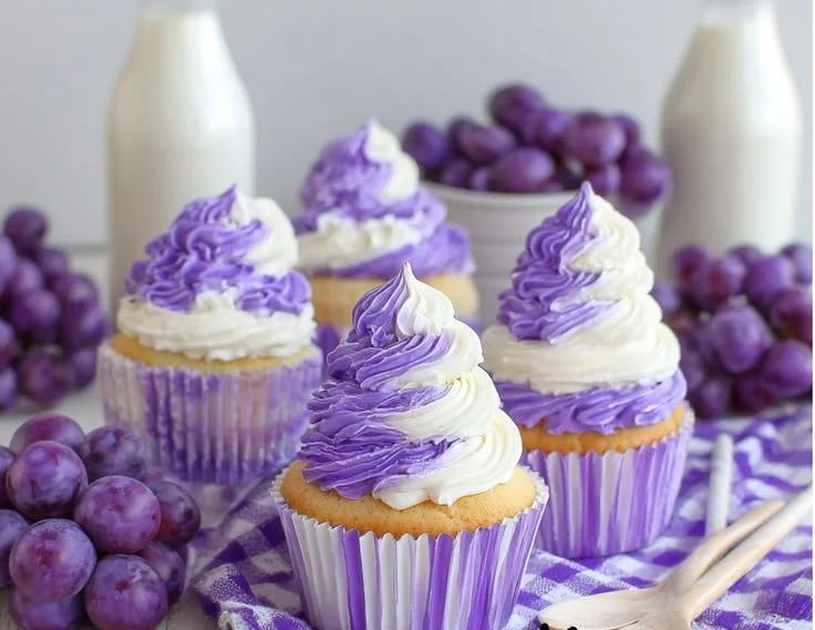 Grape soda cupcakes topped with purple frosting and colorful sprinkles