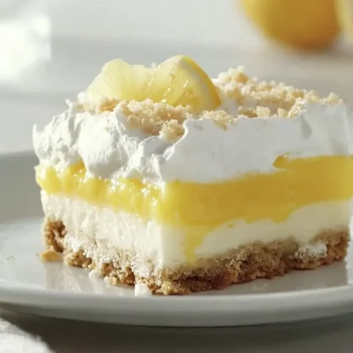 A delicious slice of Lemon Lush dessert with a vibrant lemon topping.