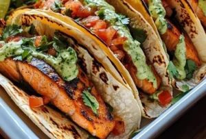 Delicious salmon tacos topped with fresh ingredients, served on a plate.
