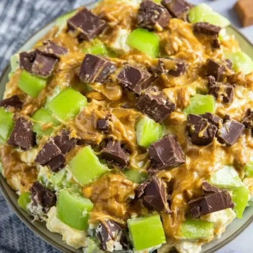 Delicious Snickers Salad with whipped cream, apples, and Snickers bars