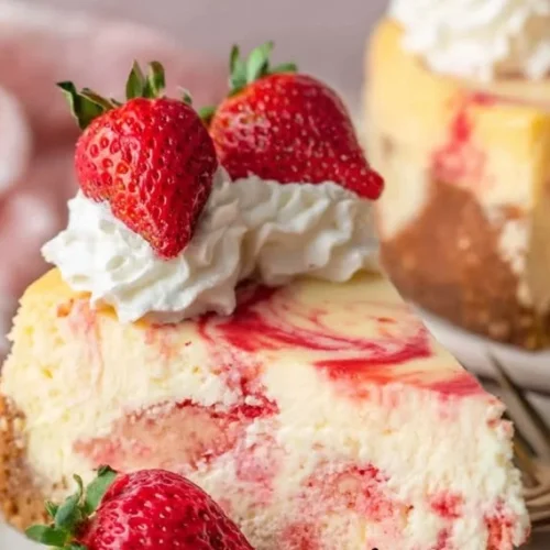 Delicious Strawberry Swirl Cheesecake topped with fresh strawberries and a creamy swirl