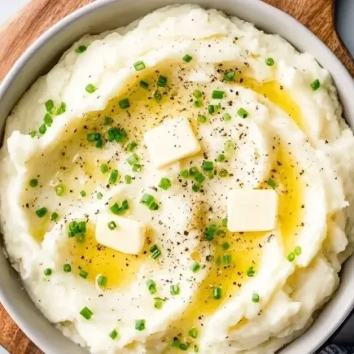 Perfect creamy mashed potatoes served in a bowl with butter and herbs