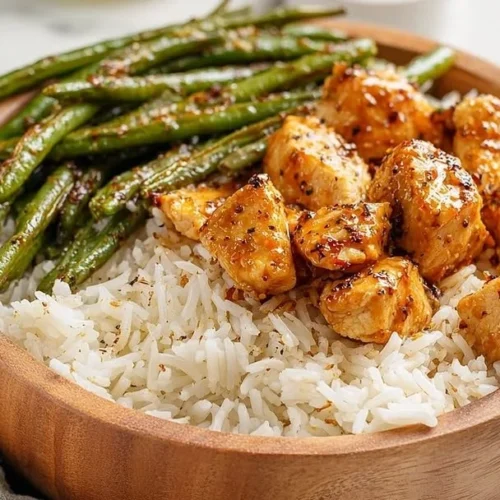 Delicious honey mustard chicken bowls garnished with fresh herbs and veggies.