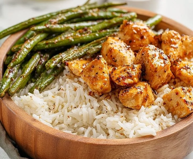 Delicious honey mustard chicken bowls garnished with fresh herbs and veggies.