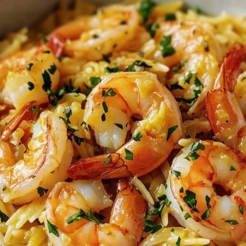 Plate of easy shrimp orzo in lemon garlic sauce garnished with parsley.