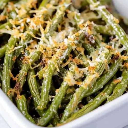 Plate of Garlic Parmesan Green Beans garnished with cheese and garlic.