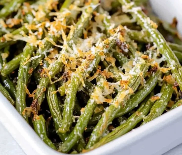 Plate of Garlic Parmesan Green Beans garnished with cheese and garlic.