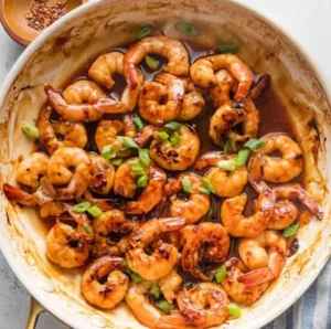 High-protein honey garlic shrimp served with vibrant vegetables on a plate.