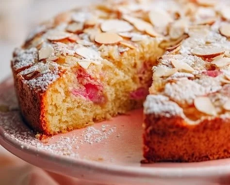 Homemade rhubarb orange cake with fresh fruit and a slice on a plate