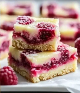 Lemon Raspberry Swirl Bars topped with fresh raspberries and lemon zest