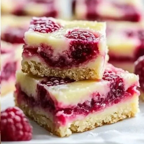 Lemon Raspberry Swirl Bars topped with fresh raspberries and lemon zest