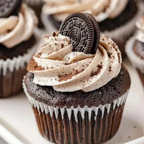 Delicious homemade Oreo Cupcakes topped with cream and cookie crumbs