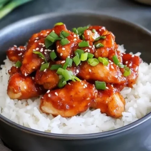 Delicious Sticky Sweet Chilli Chicken served on a plate garnished with herbs