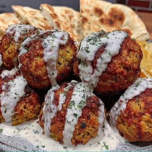 Crispy baked falafel served with herbed tahini on a plate