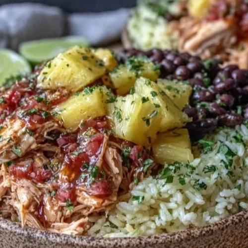 Delicious slow cooker pineapple salsa chicken burrito bowl topped with fresh ingredients.