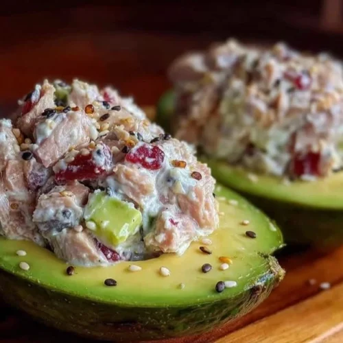 High-protein tuna stuffed avocado topped with fresh ingredients and herbs