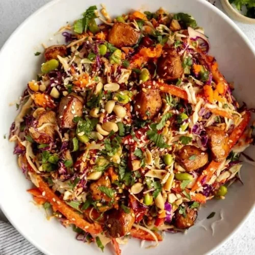 Bowl of Asian Chicken Crunch Salad with fresh vegetables and sesame dressing.
