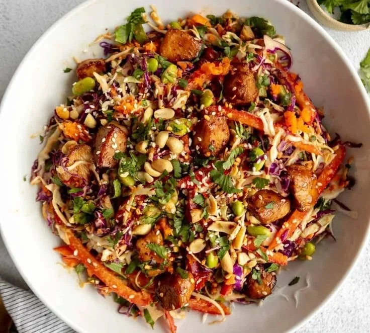 Bowl of Asian Chicken Crunch Salad with fresh vegetables and sesame dressing.