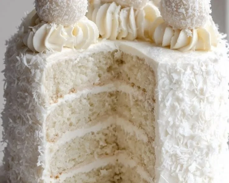 No-bake Coconut Raffaello Cake topped with coconut flakes and almonds