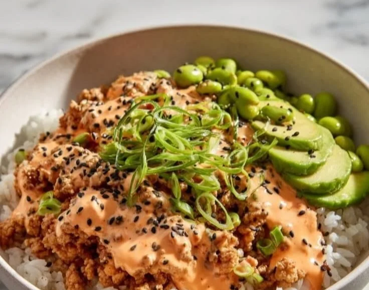 Ground turkey rice bowl topped with Bang Bang sauce and fresh vegetables