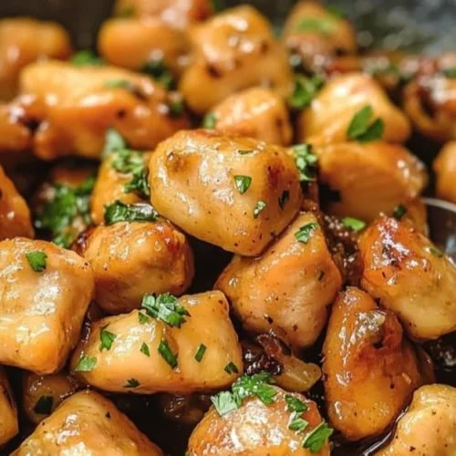 Plate of honey butter chicken garnished with fresh herbs and served over rice