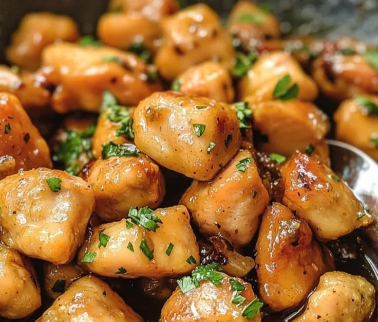 Plate of honey butter chicken garnished with fresh herbs and served over rice