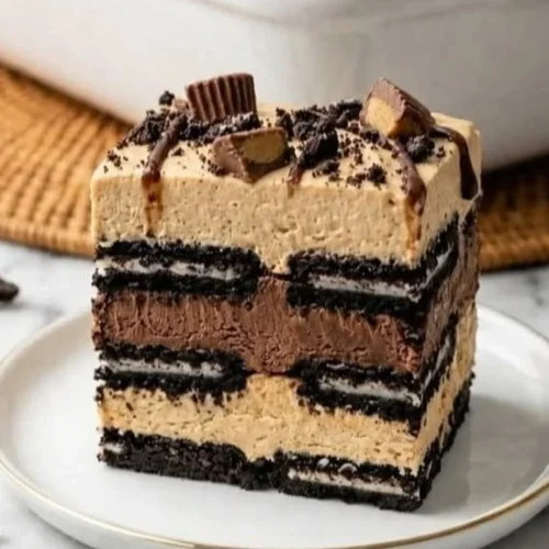 No Bake Peanut Butter Oreo Icebox Cake topped with chocolate drizzle and crushed Oreos