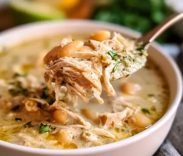Bowl of slow cooker white chicken chili topped with cilantro and cheese
