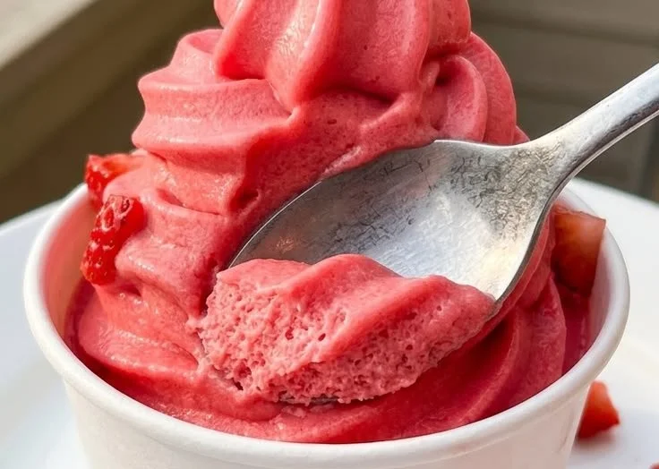 Delicious Strawberry Dole Whip in a cup with fresh strawberries on top