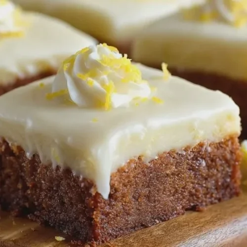 Frosted lemon brownies arranged on a plate, topped with zesty lemon frosting.
